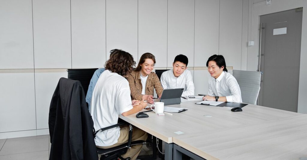Diverse team of business professionals collaborating over a tablet in a modern office setting.