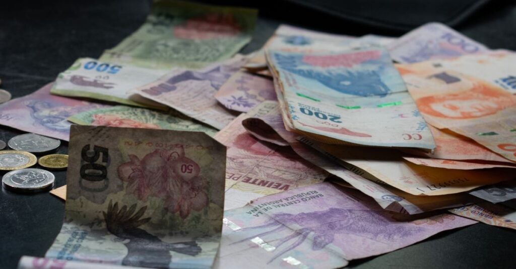 A mix of international banknotes and coins displayed on a table, highlighting diverse world currencies.
