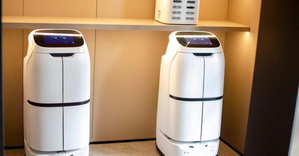 Two white robotic delivery systems located in a modern indoor room with soft lighting.