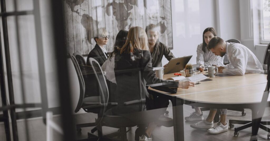 Professionals in a meeting room engaged in a collaborative business discussion.