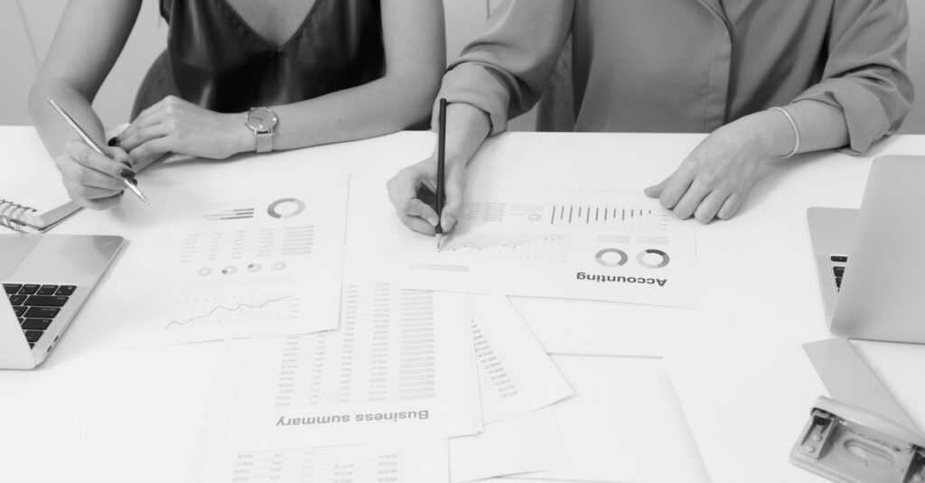 Two professionals analyzing financial documents in a modern office setting.