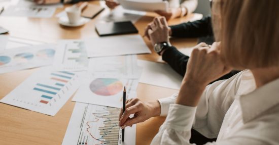Business professionals reviewing charts and graphs during a meeting in office setting.