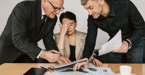 A professional team in a tense business meeting discussing financial documents.