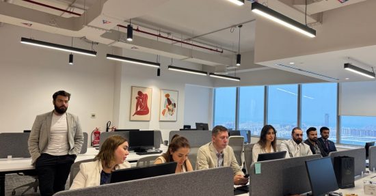 Professionals working in a modern office setting, collaborating and discussing business topics.