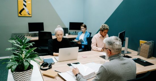 A diverse group of professionals working together in a modern office environment, focusing on teamwork and collaboration.