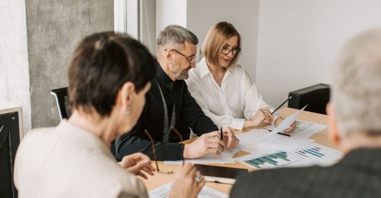 Team of professionals in office analyzing financial documents for business strategy.