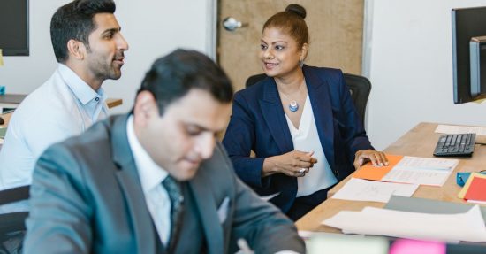 Professional team discussing project ideas in an office setting, featuring diverse employees.