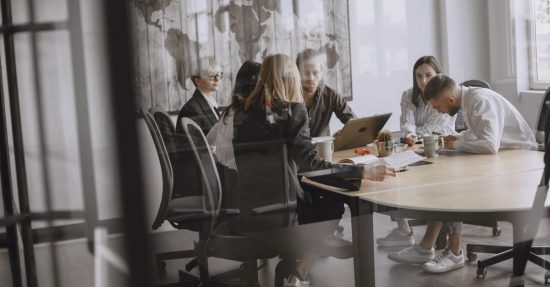 Professionals in a meeting room engaged in a collaborative business discussion.