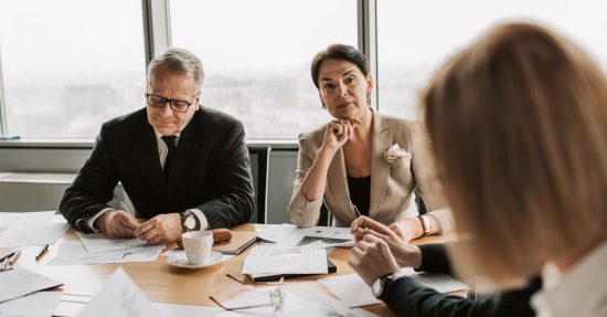 Business professionals in discussion during a meeting in a modern office setting.