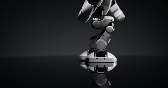 A close-up image of a mechanical robotic arm reflecting on a dark surface, capturing industrial innovation.