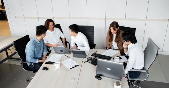 Group of coworkers brainstorming ideas during a collaborative team meeting in a bright office.